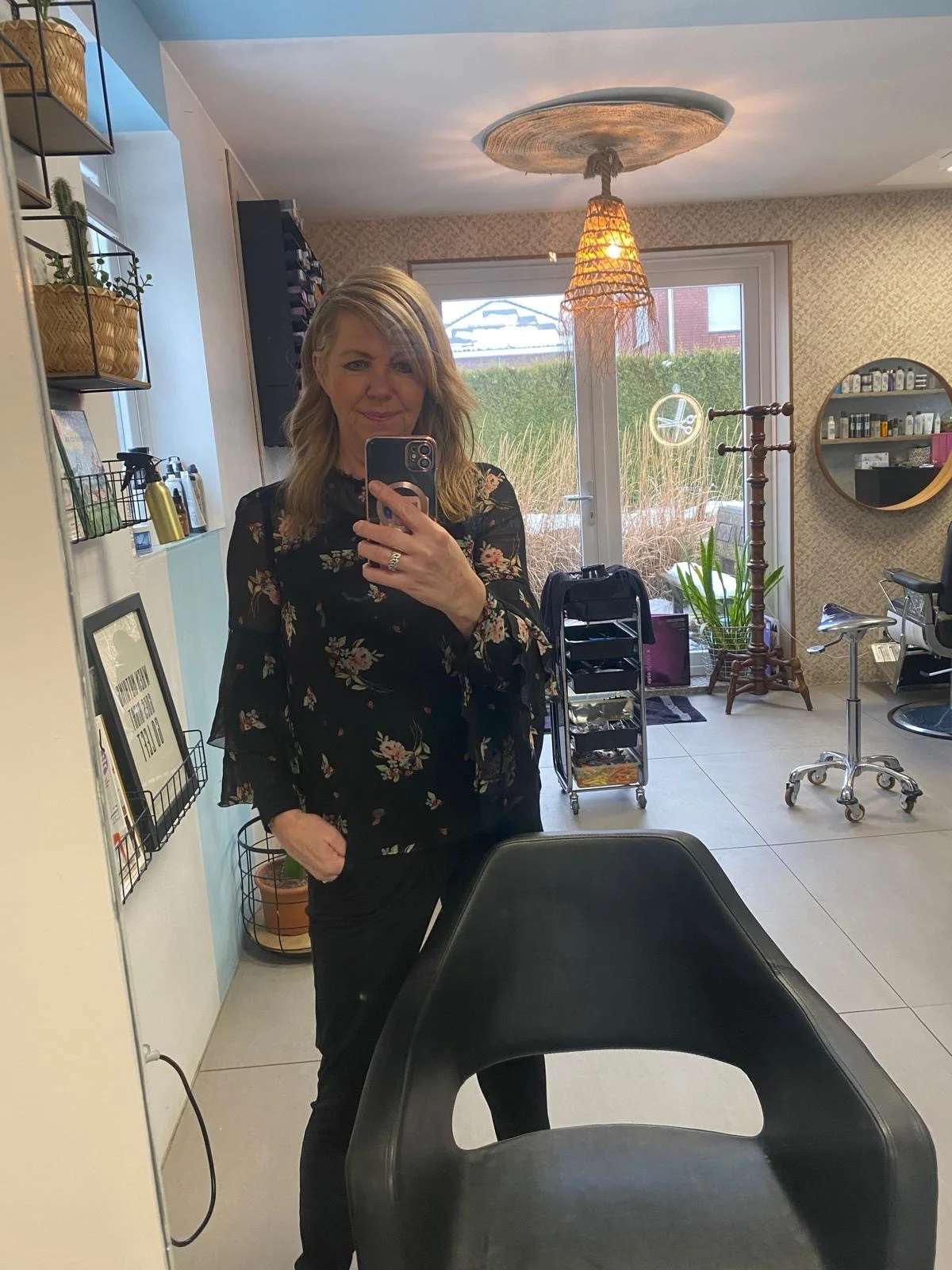 Eigenaresse van Studio Tanner in de salon, gefotografeerd in de spiegel