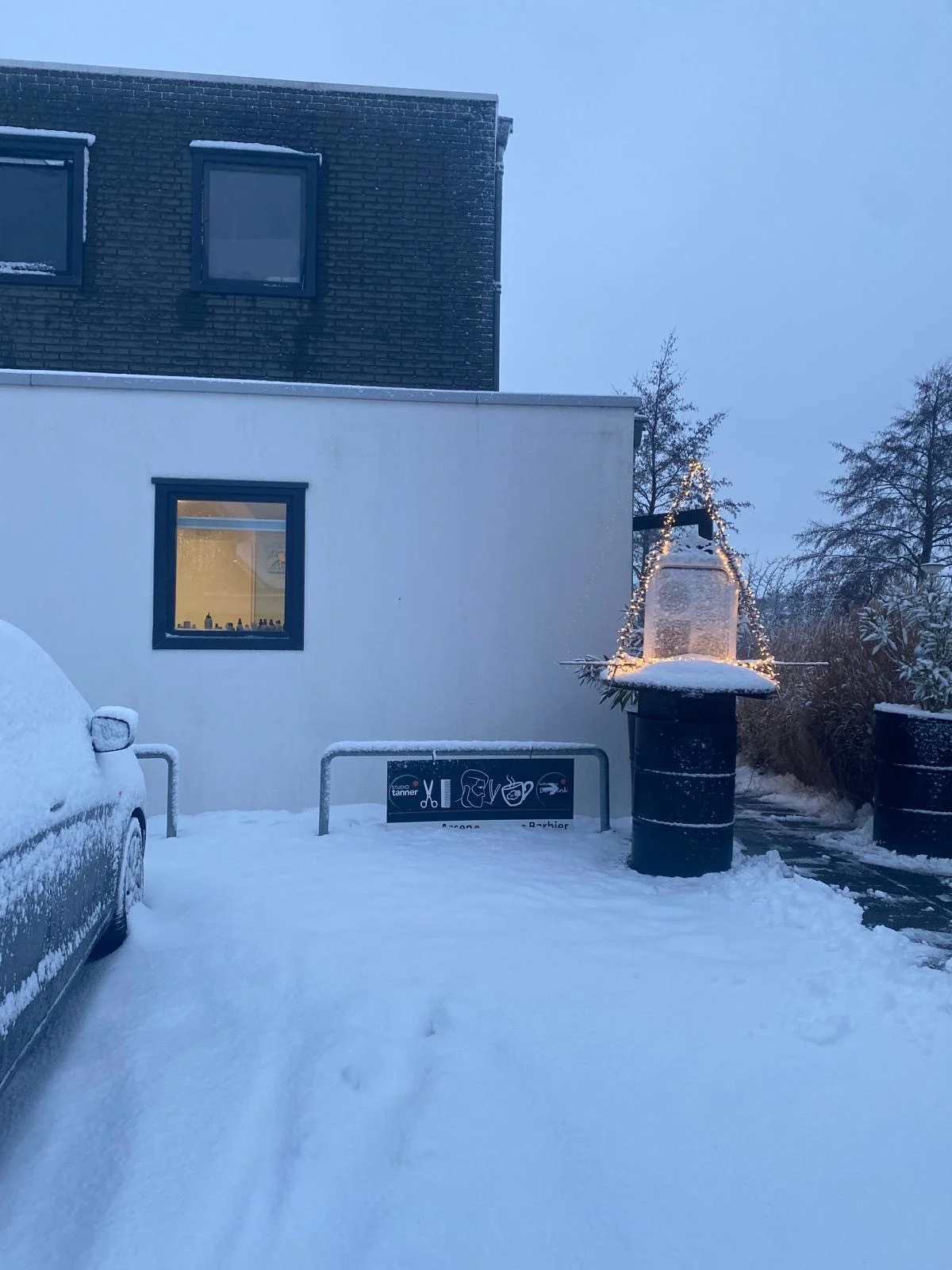Studio Tanner in de sneeuw, met het raam verlicht